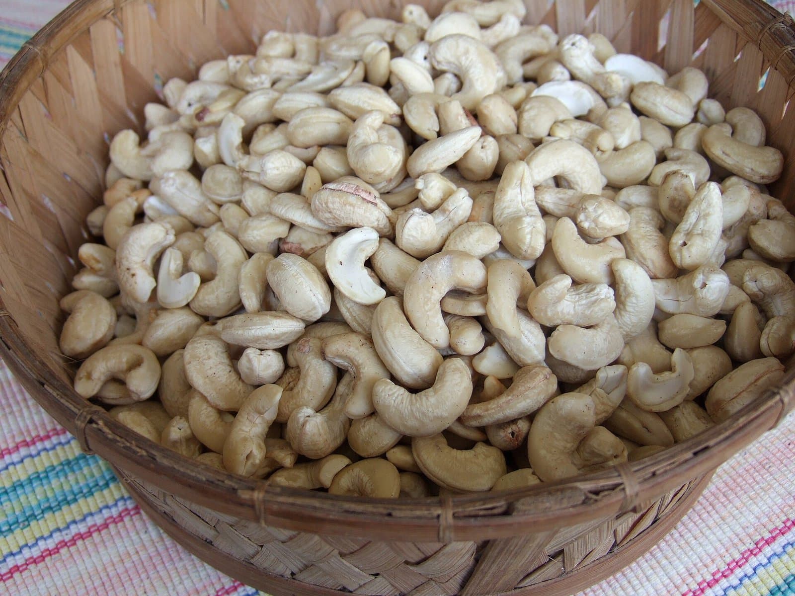 Raw cashew nuts in an 80 kg bag with a cut-test sample board alongside