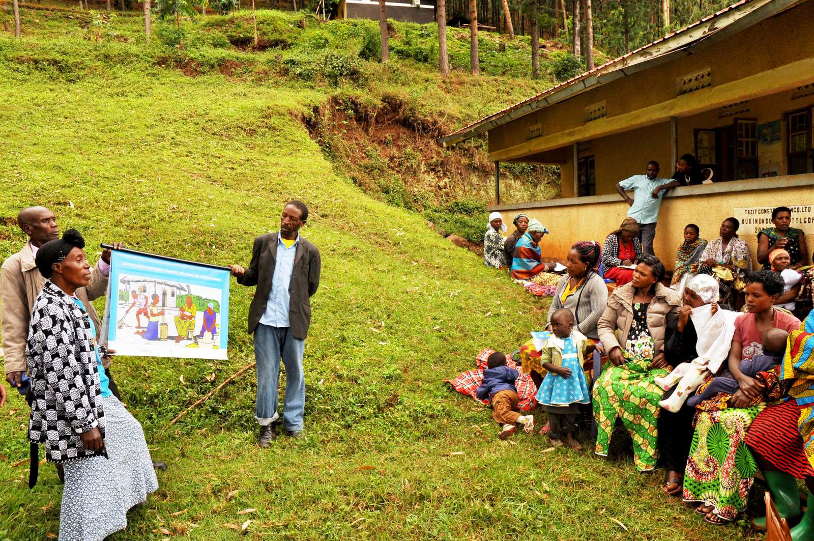 Farmer training session in progress, an agronomist demonstrating post-harvest handling to a seated group