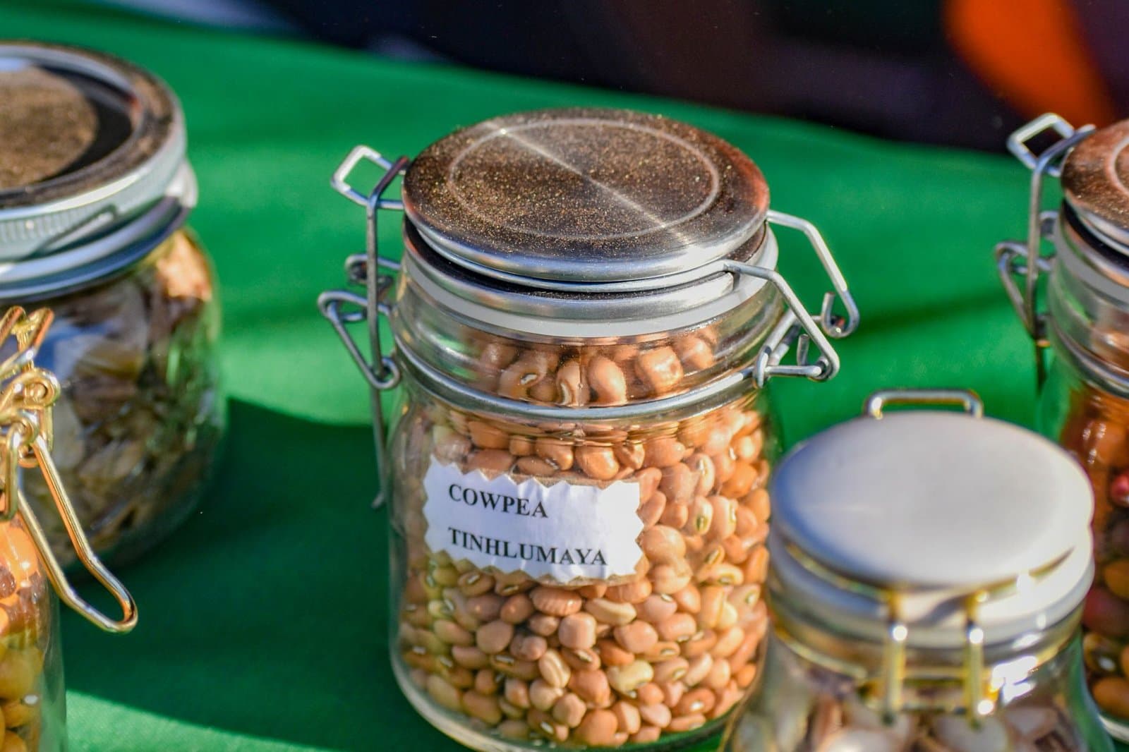Company exhibition stand with product samples in labelled display jars and branded backdrop