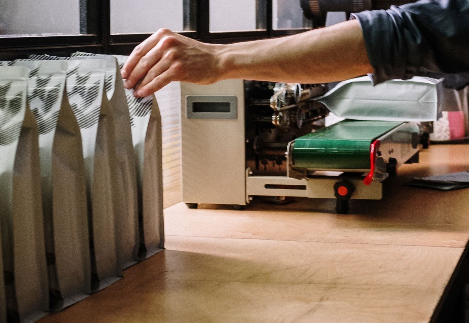 Printed retail packs of varying sizes standing upright, shelf-ready, on a packing bench