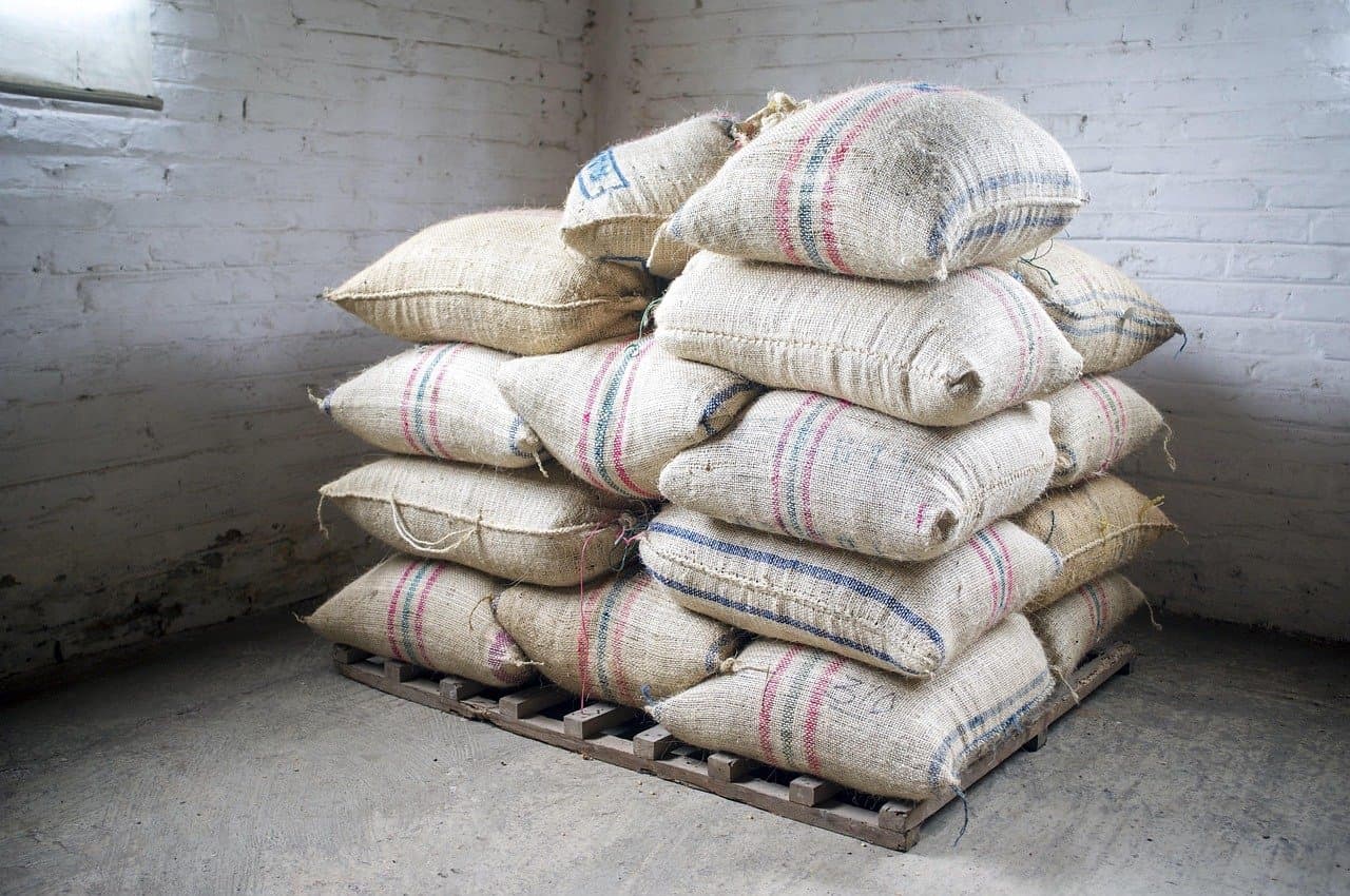 Clean, well-lit warehouse interior with stacked bags on pallets and clear aisles between stacks