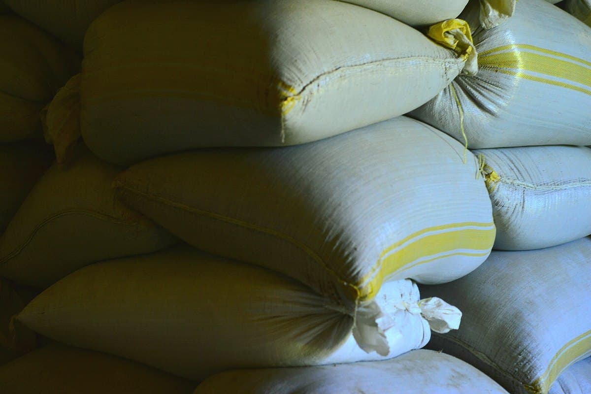 Stacked commodity bags with visible batch identification cards on each stack