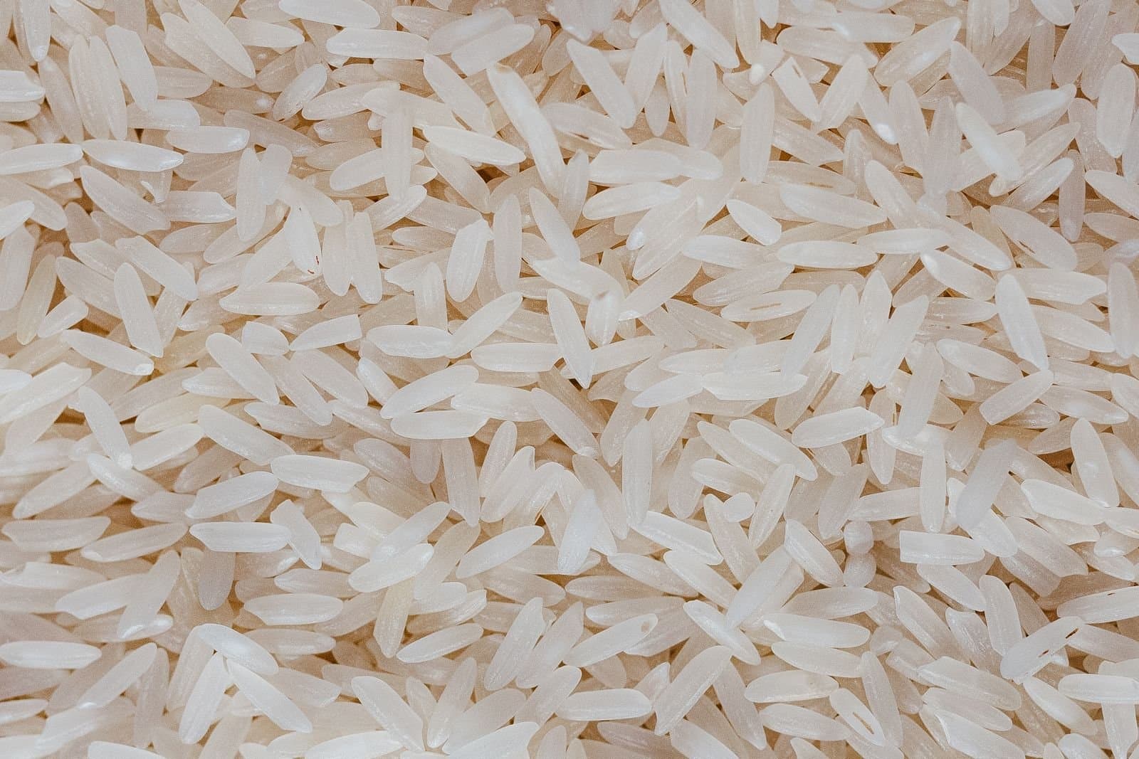Close-up of cleaned long-grain white rice filling the frame, showing grain length and uniformity