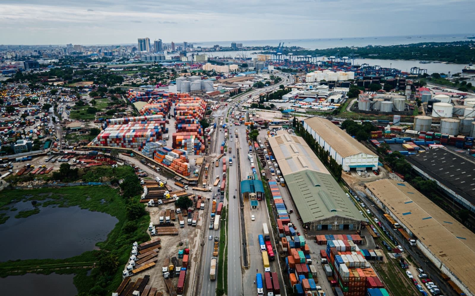 Aerial view over the Port of Dar es Salaam — container yards, transit sheds and the container berths with their gantry cranes, the exit point for seaborne consignments