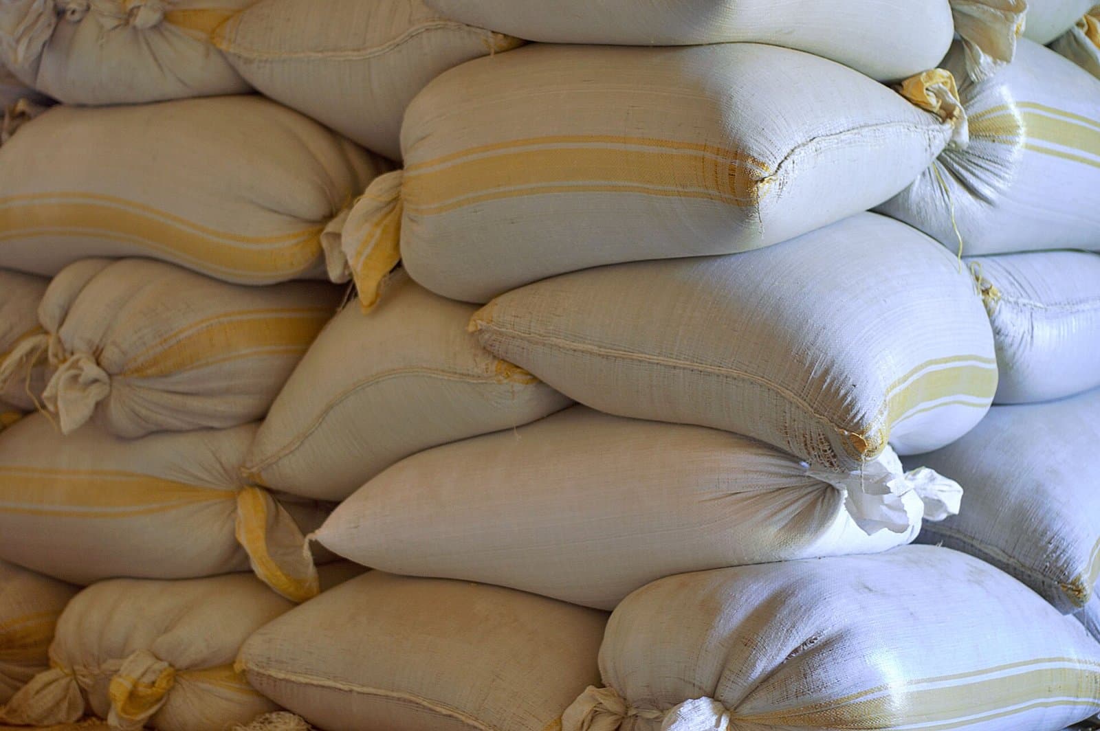 Filled and tied woven polypropylene sacks stacked for storage
